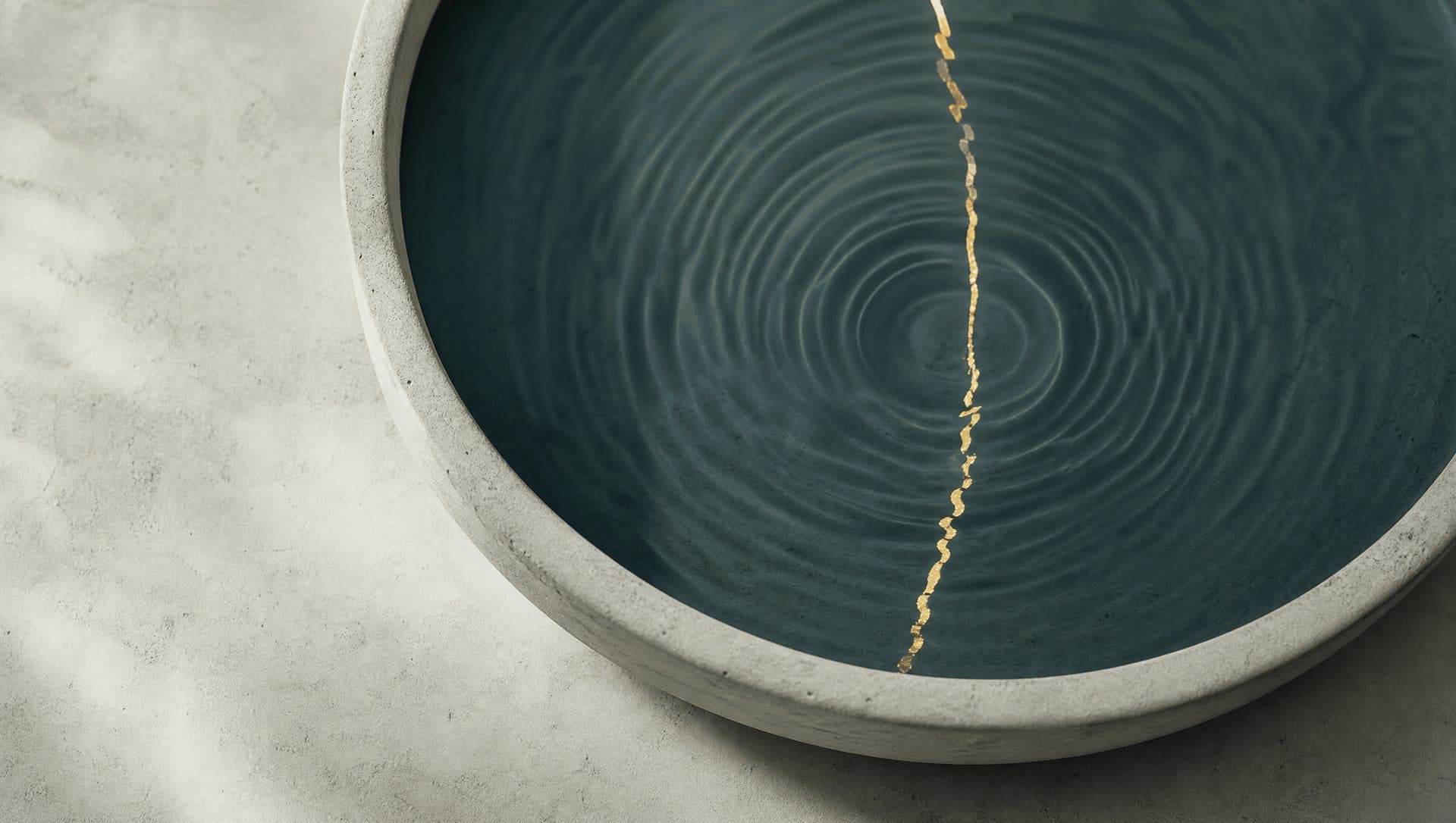 The still surface of a shallow basin of deep teal water seen from above, with faint concentric ripples and one thin brass line of reflected light.